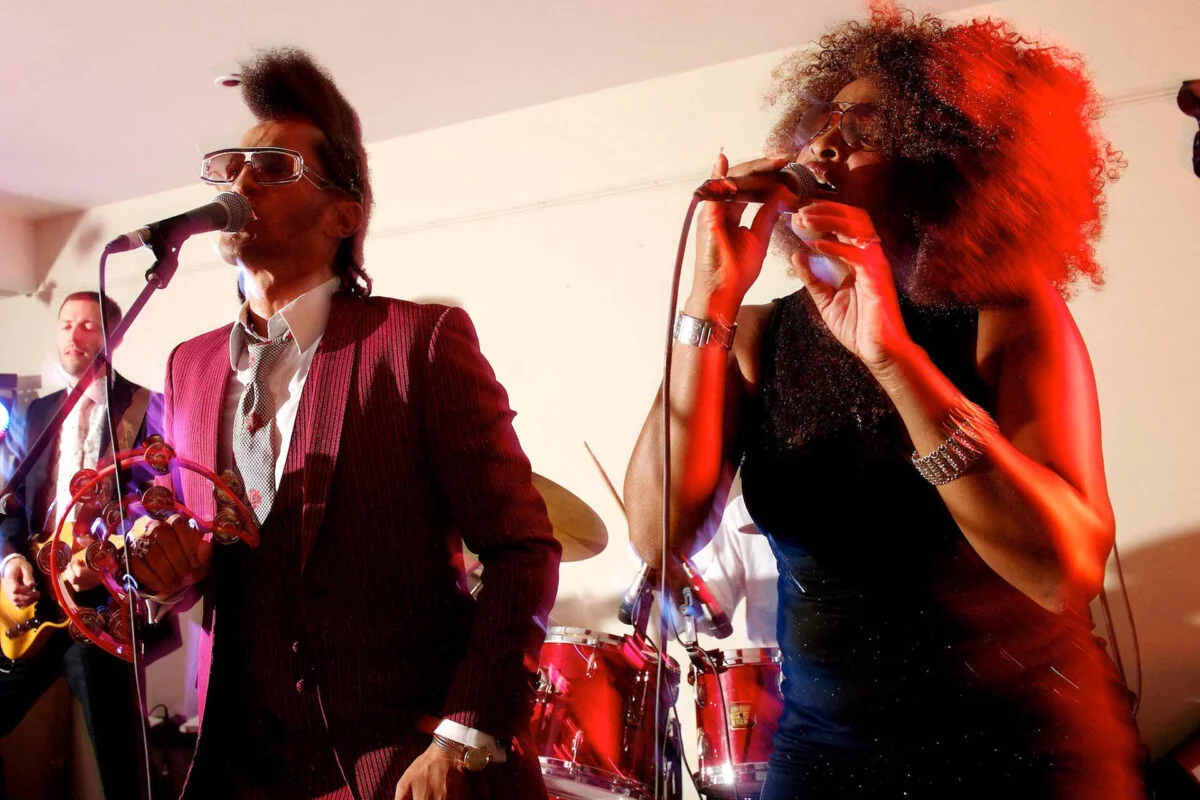 A group of people singing into microphones at a party.
