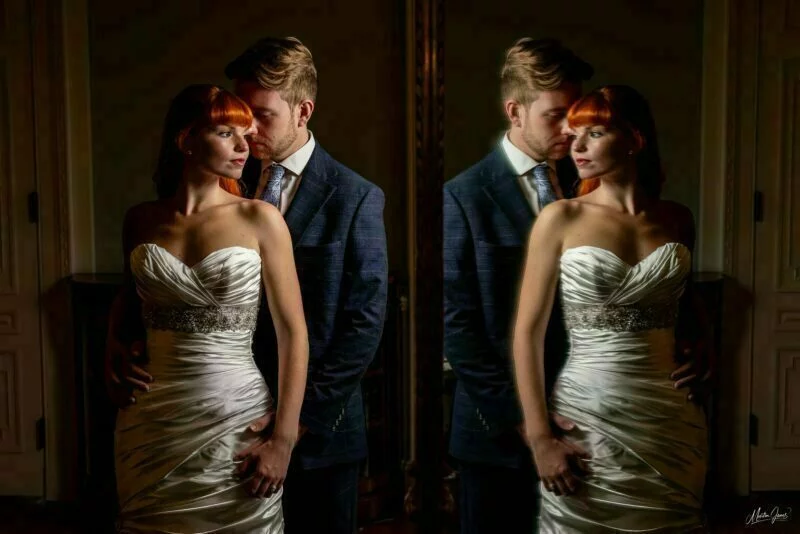 A bride and groom posing in front of a mirror.