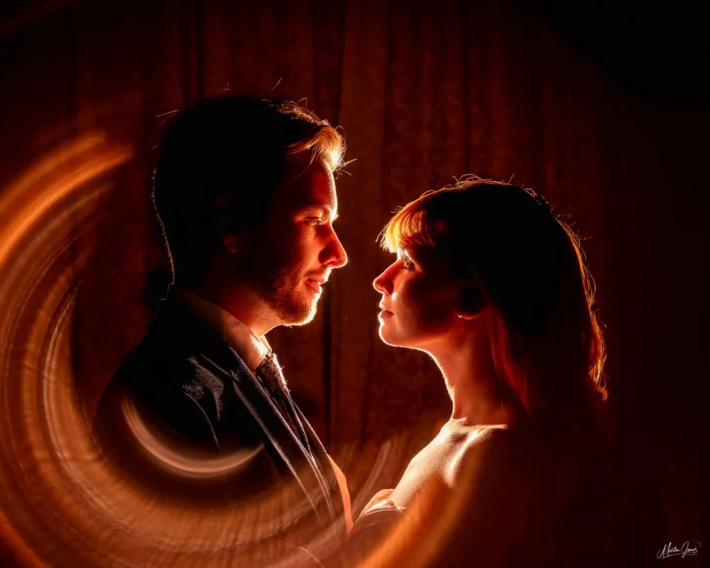 A man and woman standing in front of a circular light.