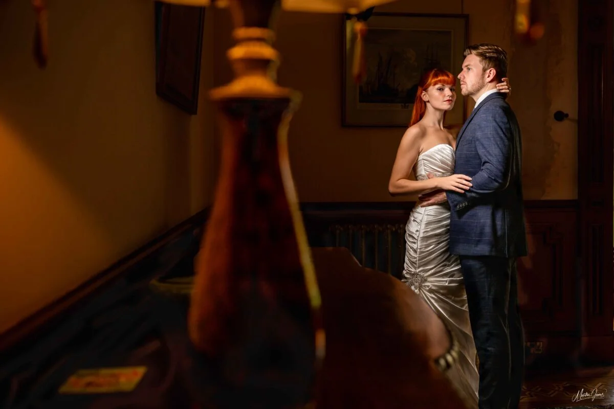 A bride and groom embracing in a dark room.