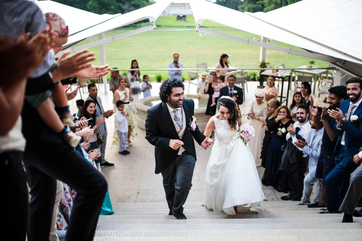 A bride and groom walking down the stairs at a wedding.