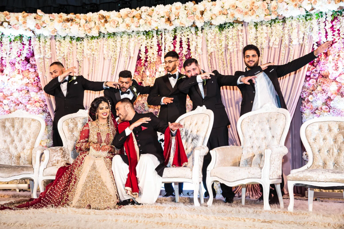 A group of groomsmen posing for a photo at a wedding.
