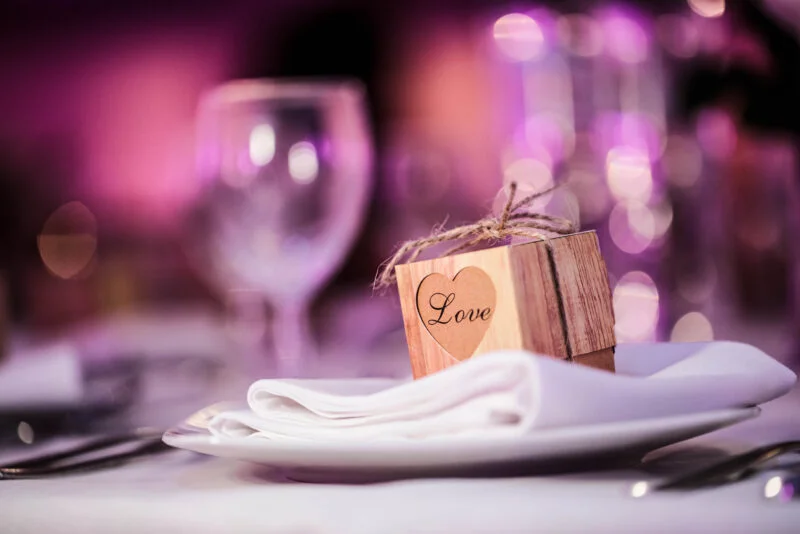 A wooden box sits on a plate at a wedding reception.