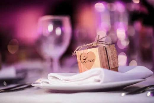 A wooden box sits on a plate at a wedding reception.