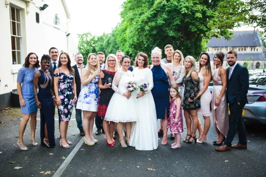 A wedding party posing for a photo in front of a building.
