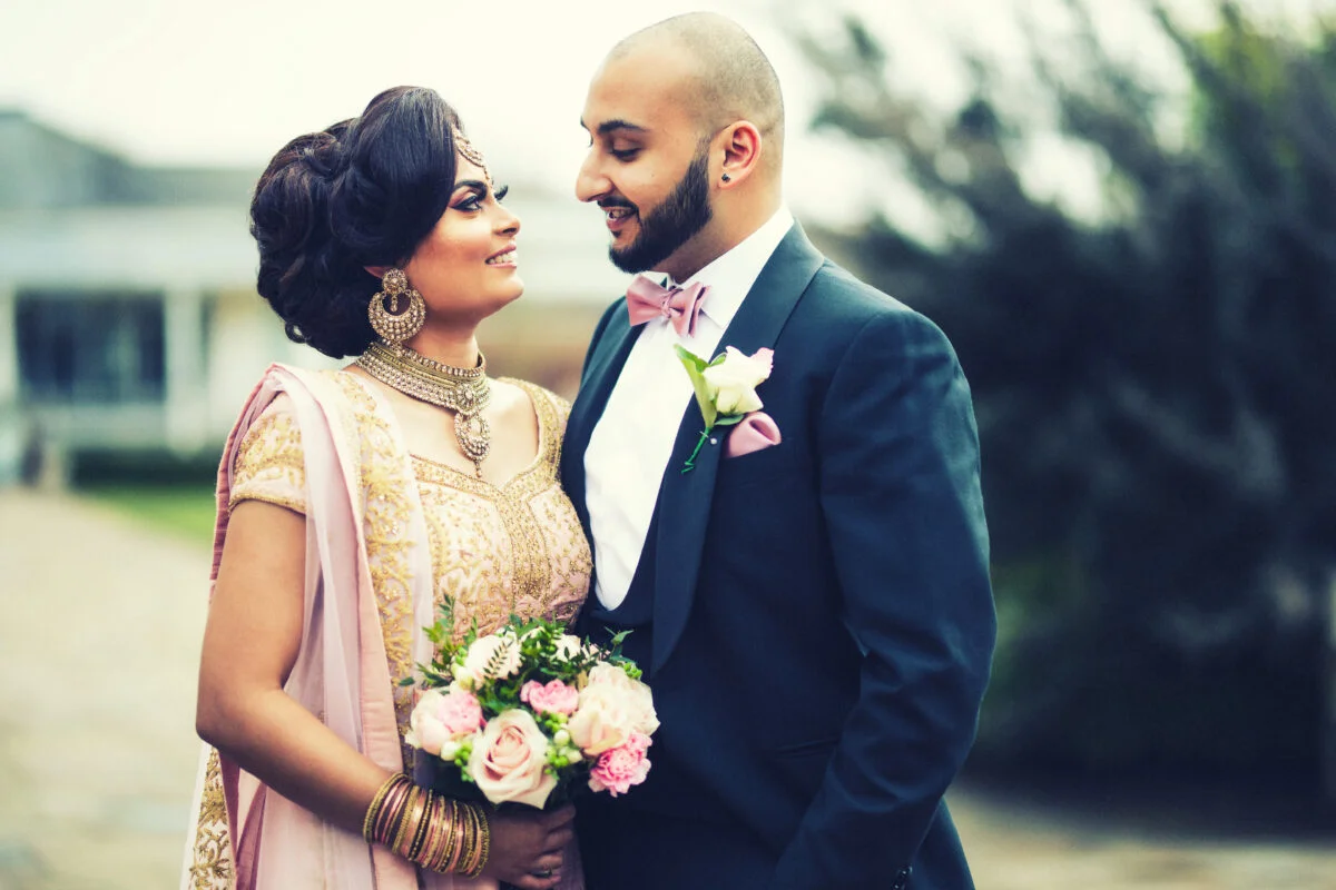 An indian bride and groom standing next to each other.