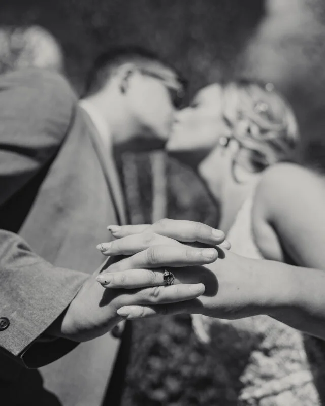 A bride and groom kissing in black and white.