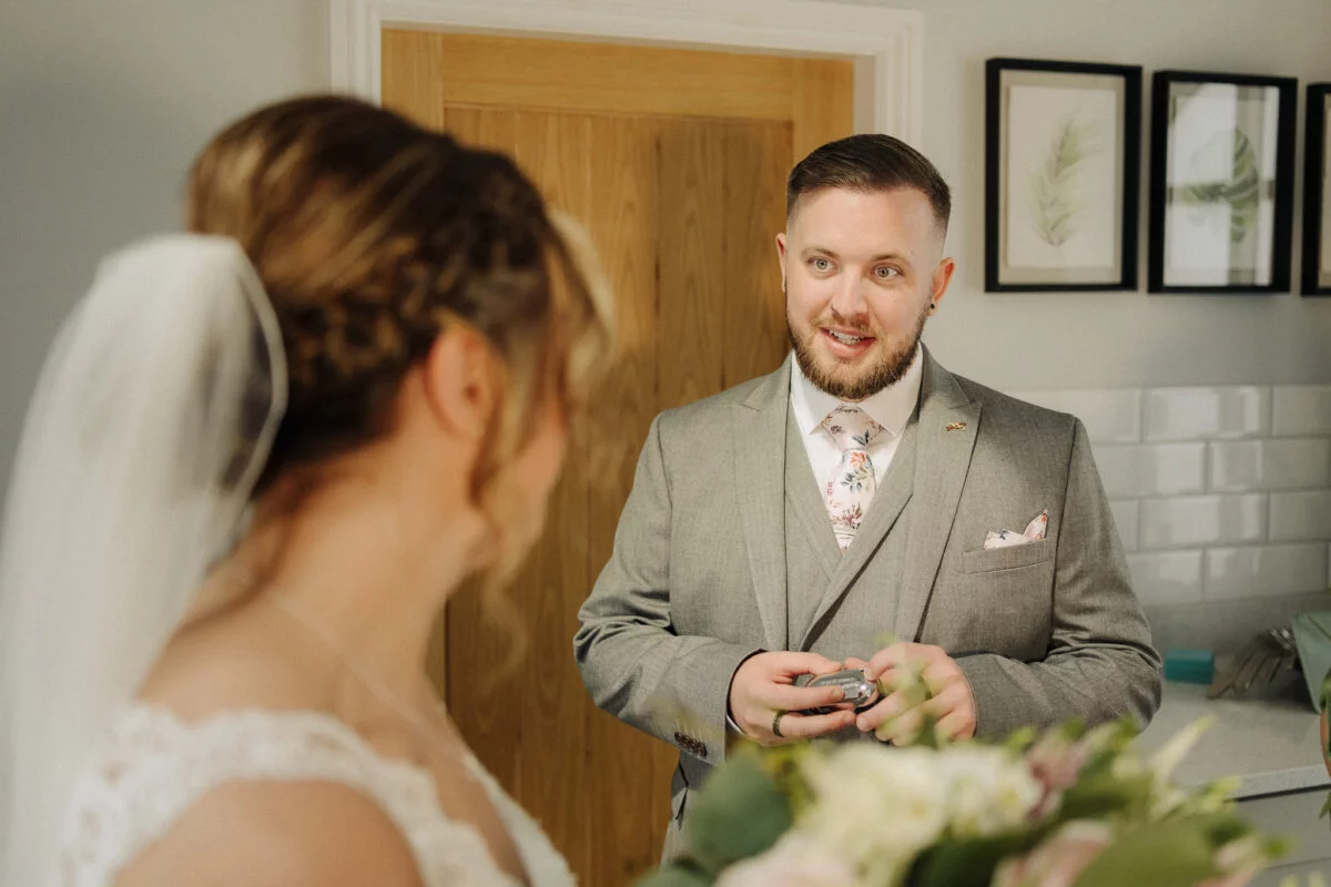 A bride and groom looking at each other in the mirror.