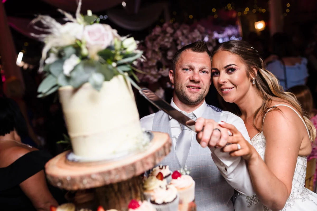 A bride and groom cutting their wedding cake.