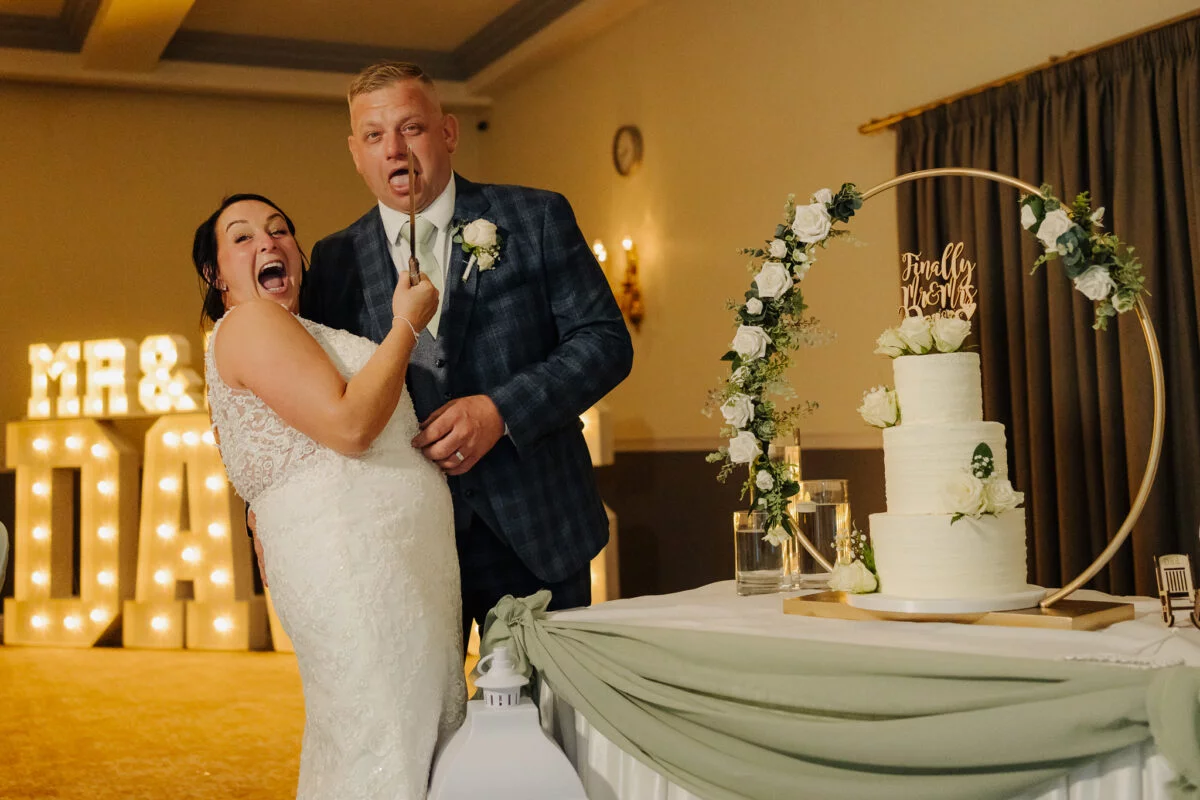 A bride and groom cutting their wedding cake.