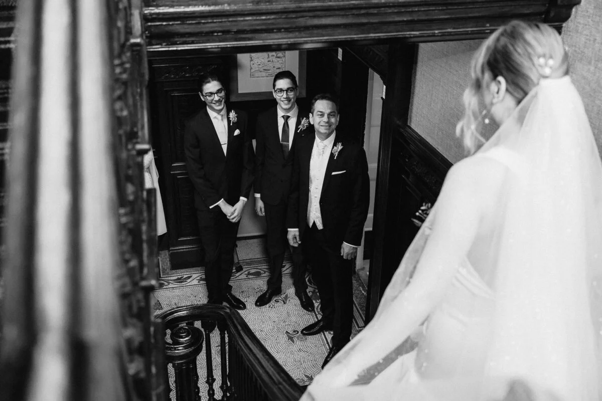 A bride and her bridesmaids are walking down the stairs.