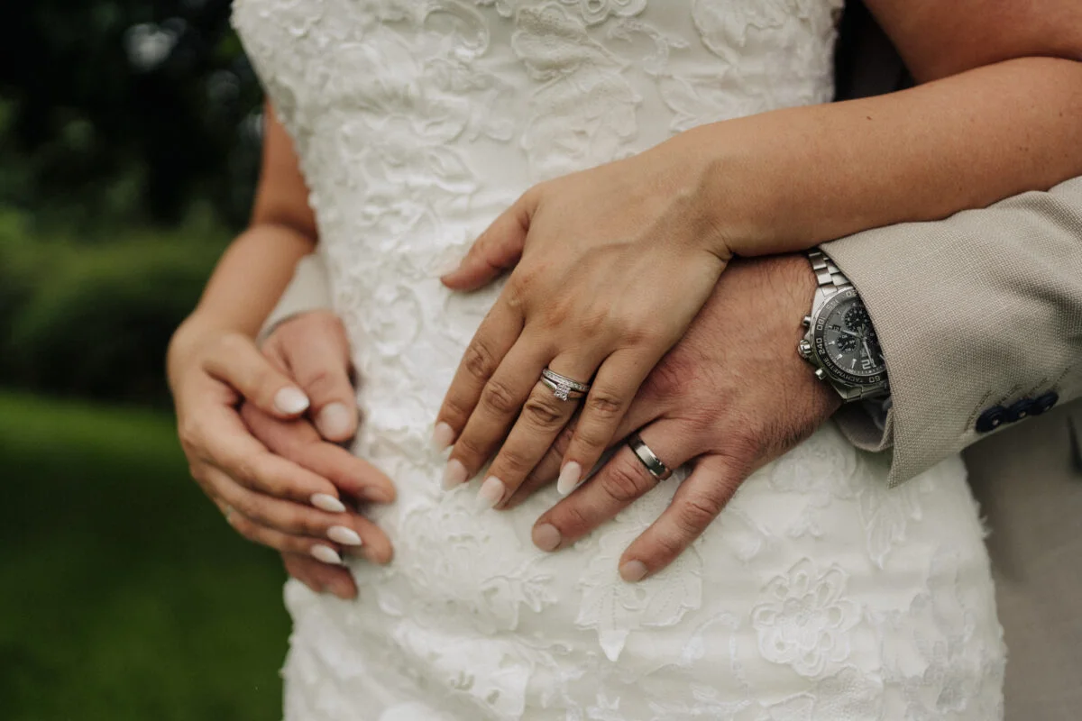 A bride and groom are holding each other's hands.