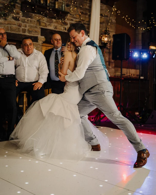 A bride and groom dancing on the dance floor.