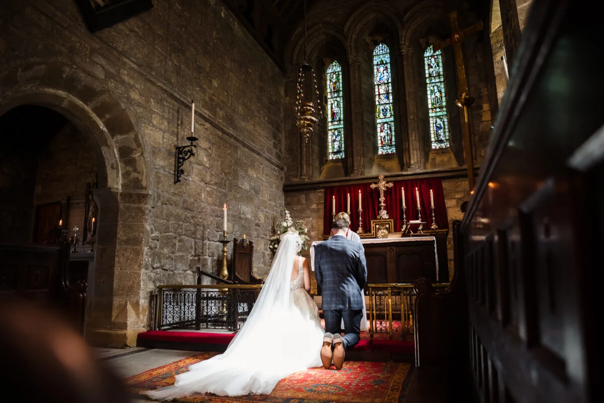 A bride and groom walking down the aisle of a church.
