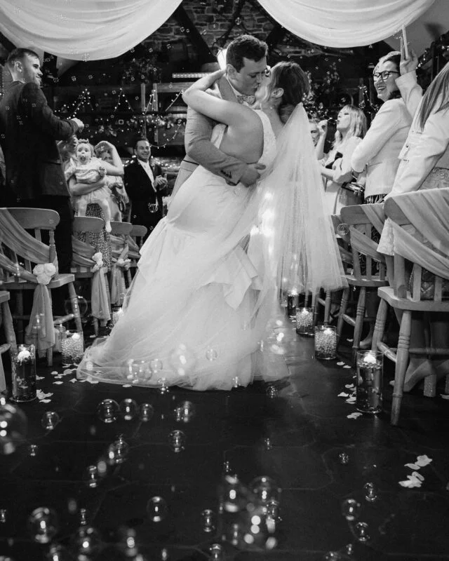 A bride and groom kiss during their wedding ceremony.