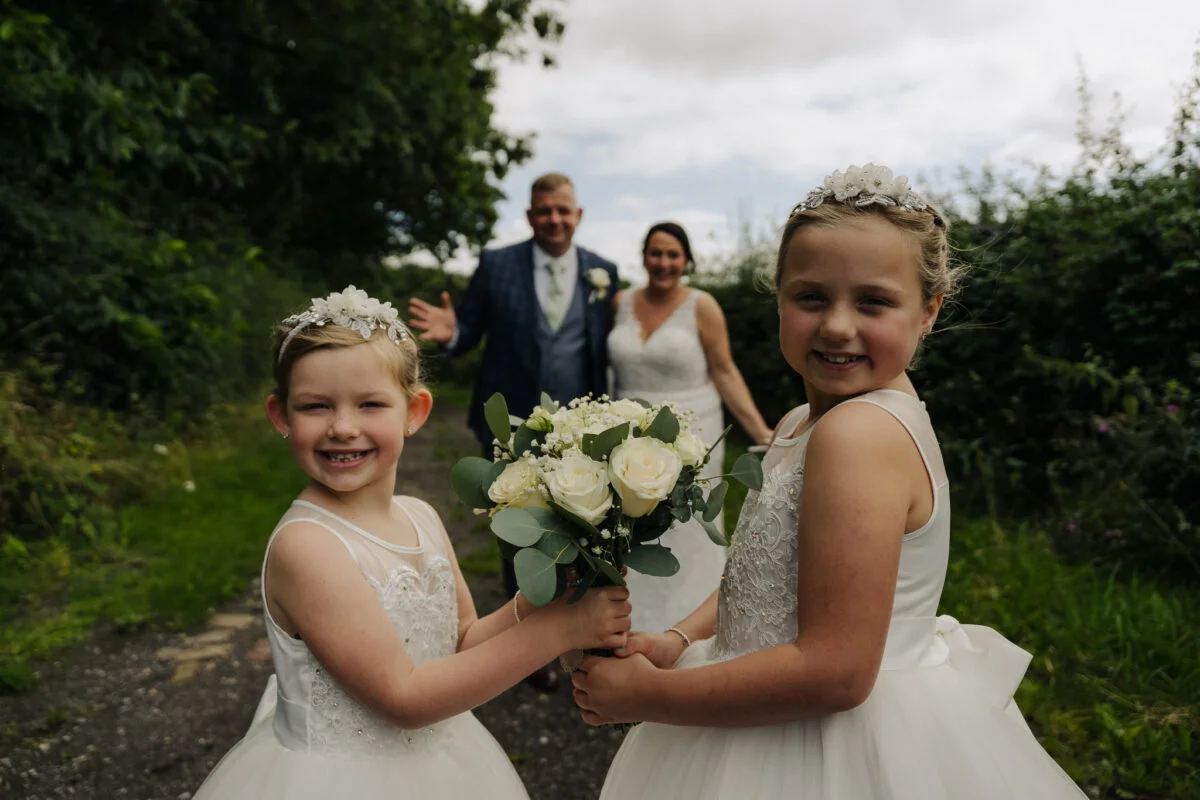 A group of bridesmaids holding bouquets on a path.