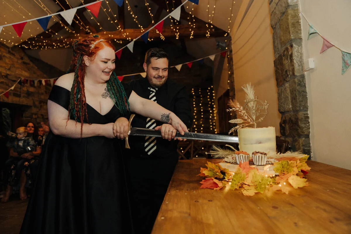 A man and woman cutting a cake with a knife.