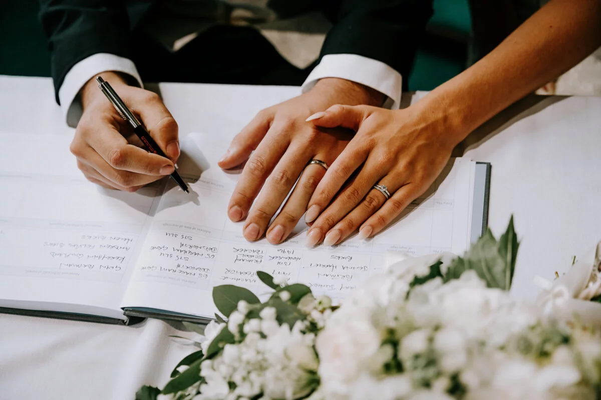 A bride and groom signing their wedding vows.