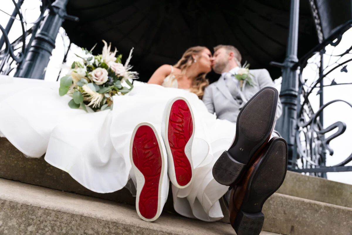 A pair of shoes with a bride and groom kissing.