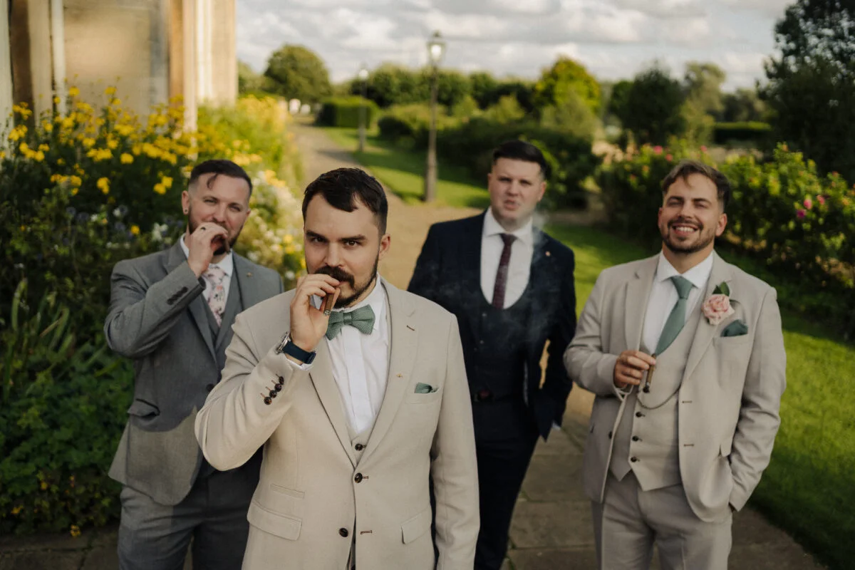 A group of groomsmen smoking a cigarette.