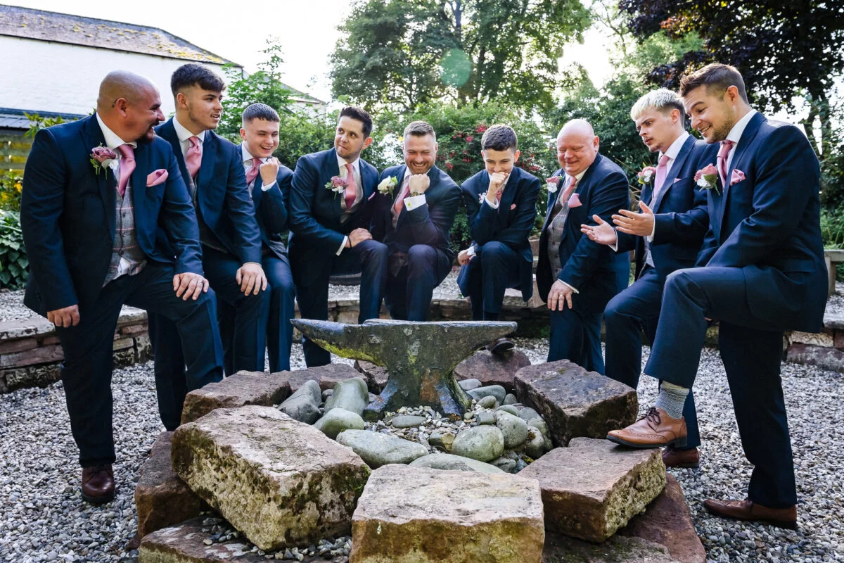 A group of groomsmen posing in front of a fire pit.