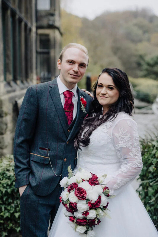 A bride and groom posing for a photo in front of a building.