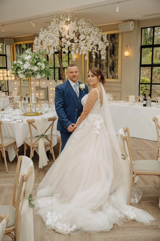 A bride and groom posing for a photo in a wedding room.