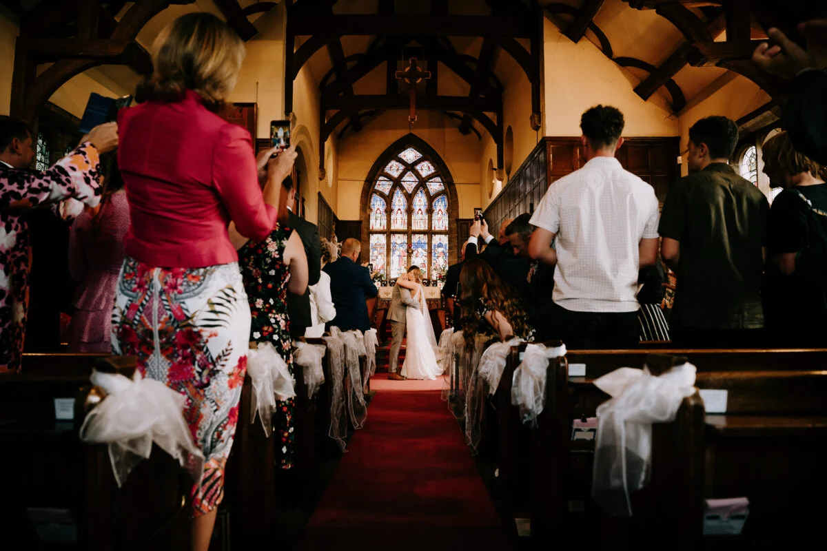 A bride walks down the aisle of a church.