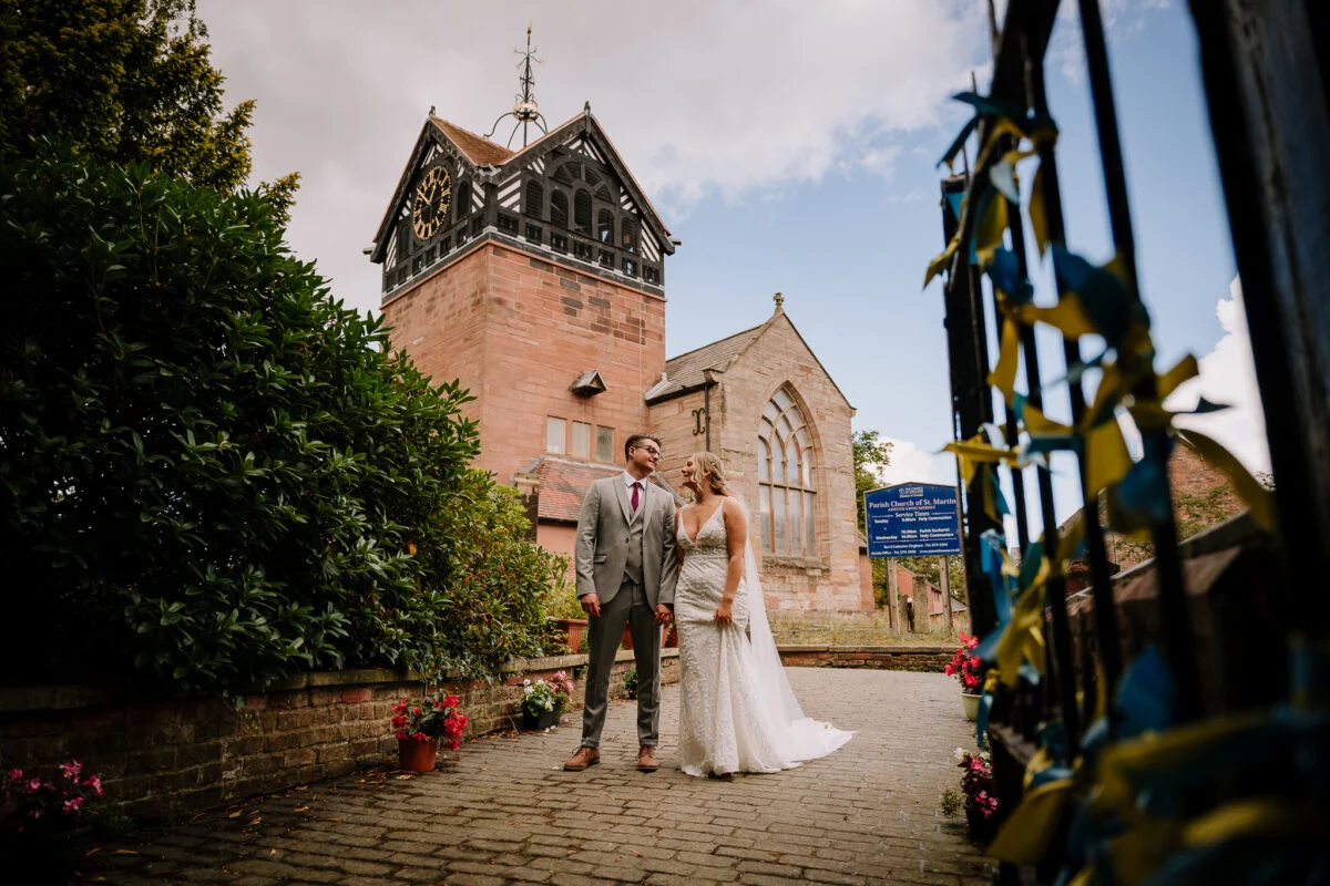 A bride and groom standing in front of a church.