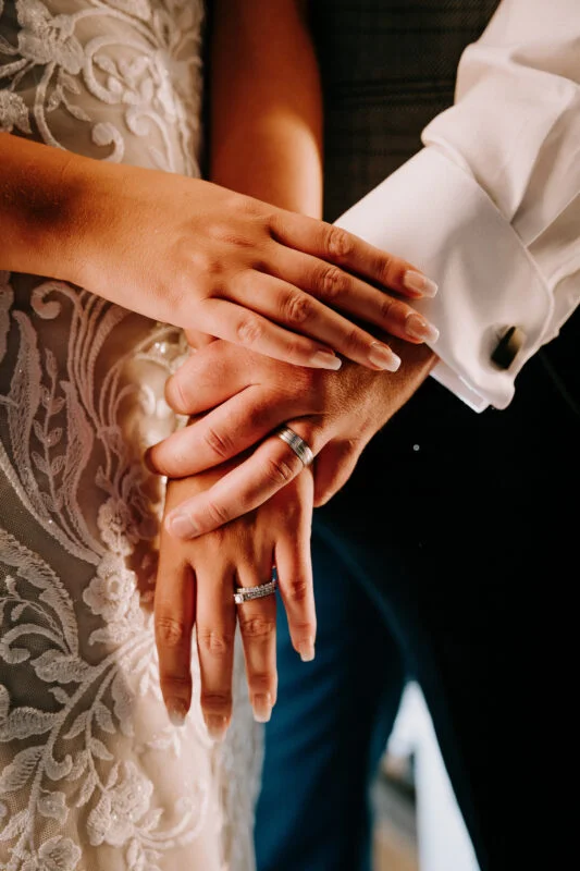 A bride and groom holding hands at their wedding.