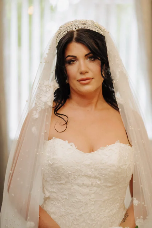 A bride in a wedding dress is posing for a picture.