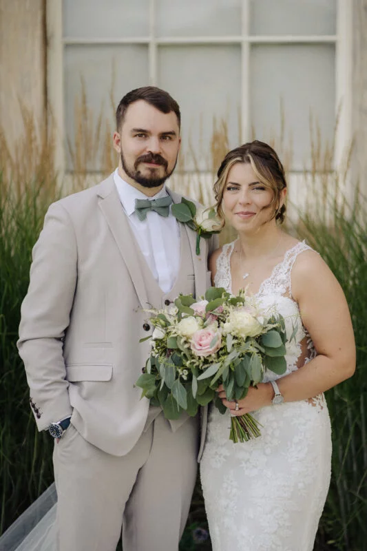A bride and groom standing in front of a building.