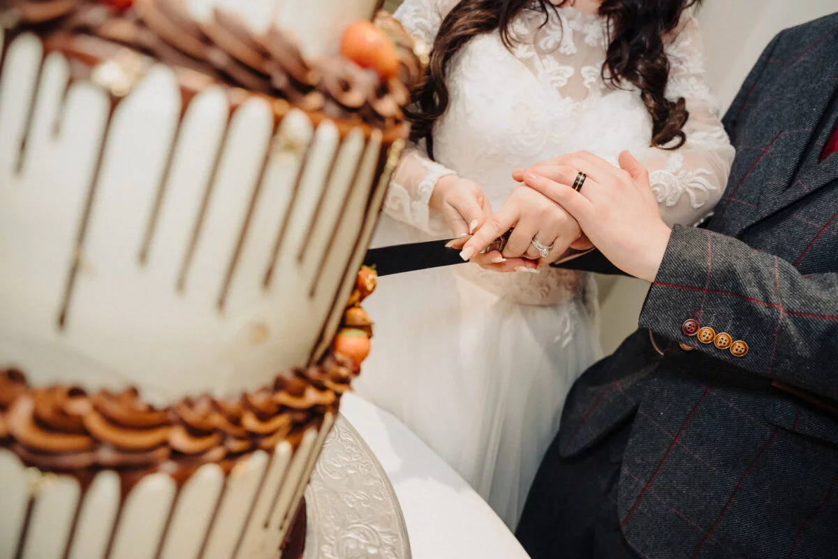 A bride and groom cutting a wedding cake.