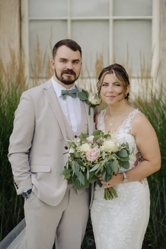 A bride and groom standing in front of a building.