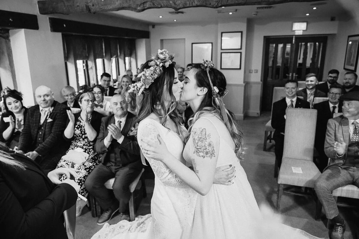 A bride and groom kiss during their wedding ceremony.