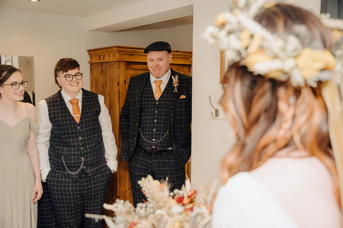 A bride and groom standing in front of a mirror.
