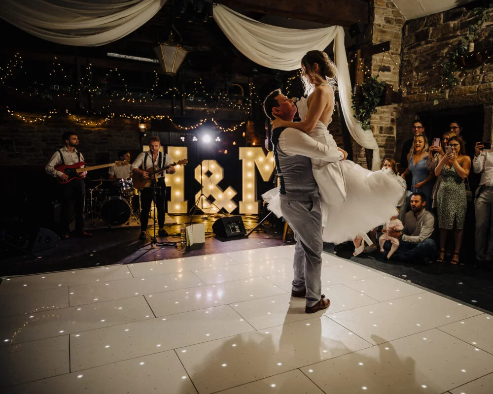 A bride and groom dancing on the dance floor at their wedding.