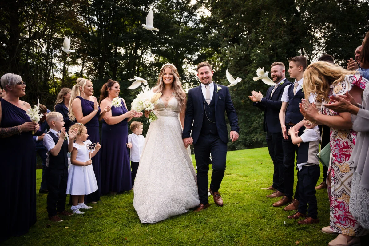 A bride and groom walk down the aisle at a wedding.