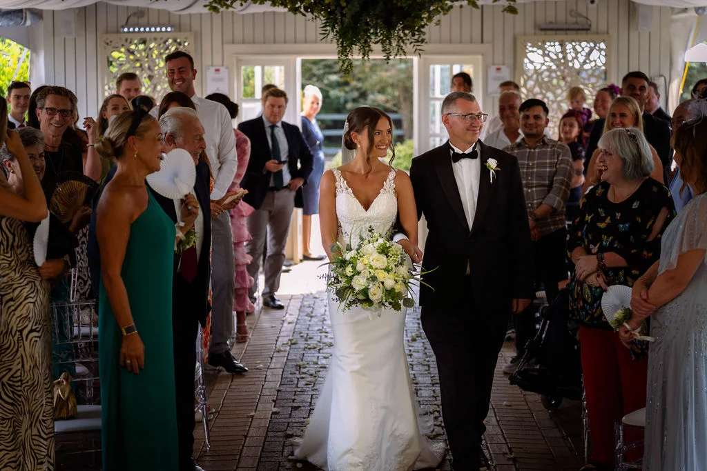 A bride and groom walking down the aisle at a wedding.