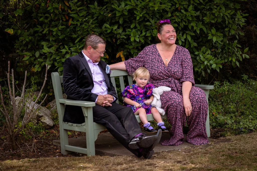 A woman and a child sitting on a bench.