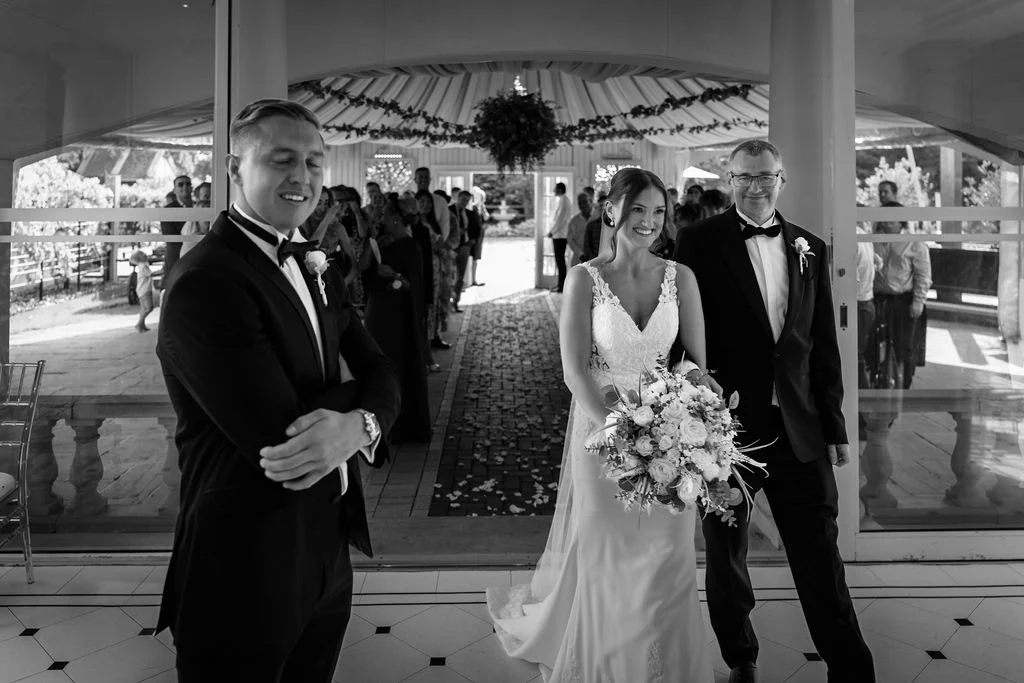 A bride walks down the aisle with her father.