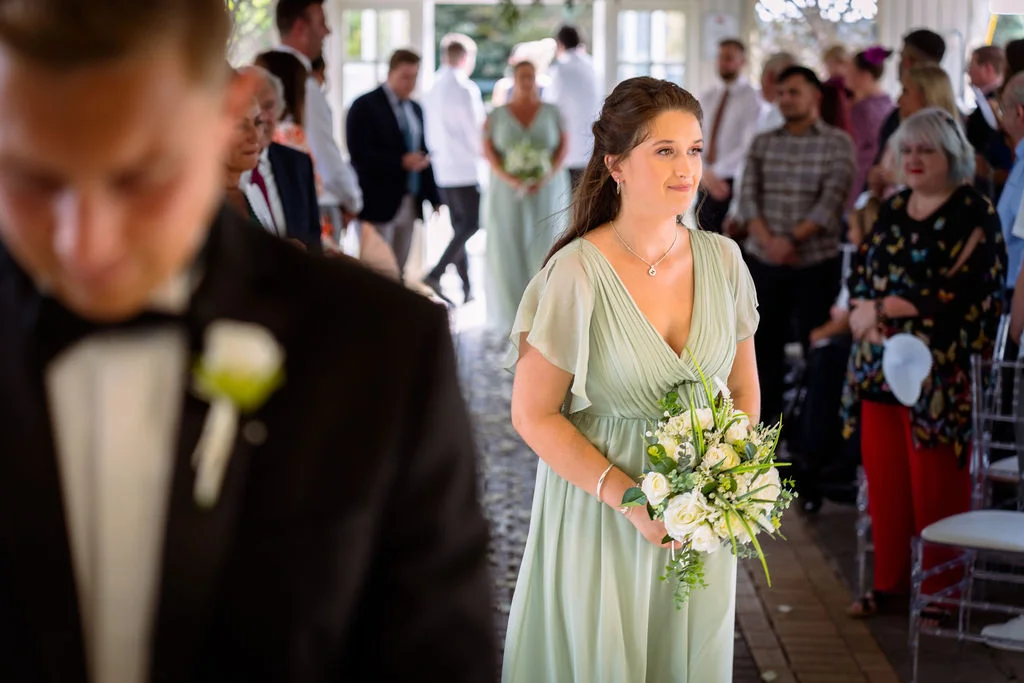 A bride walks down the aisle with her bridesmaids.