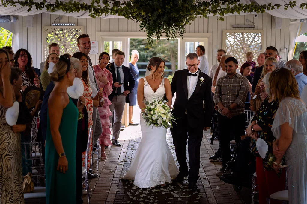 A bride and groom walking down the aisle at their wedding.