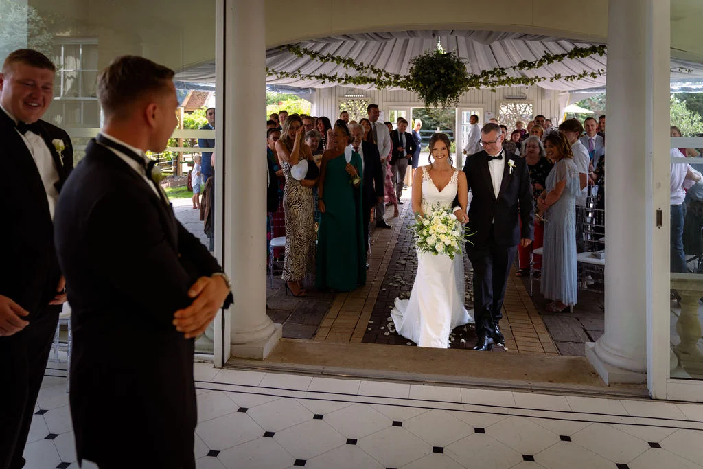 A bride and groom walking down the aisle at a wedding.
