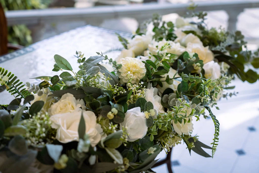 An arrangement of white and green flowers on a table.