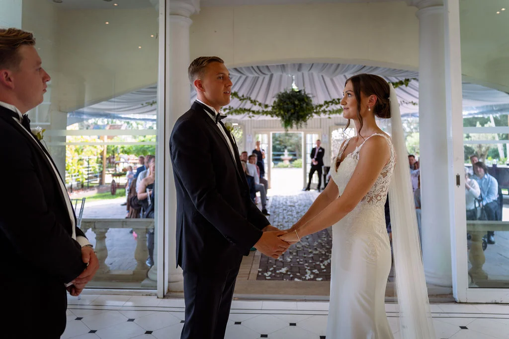 A bride and groom standing in front of a doorway.