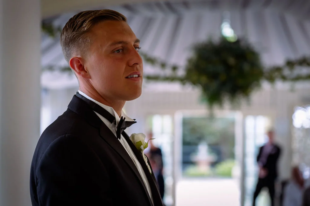 A man in a tuxedo standing in a room.