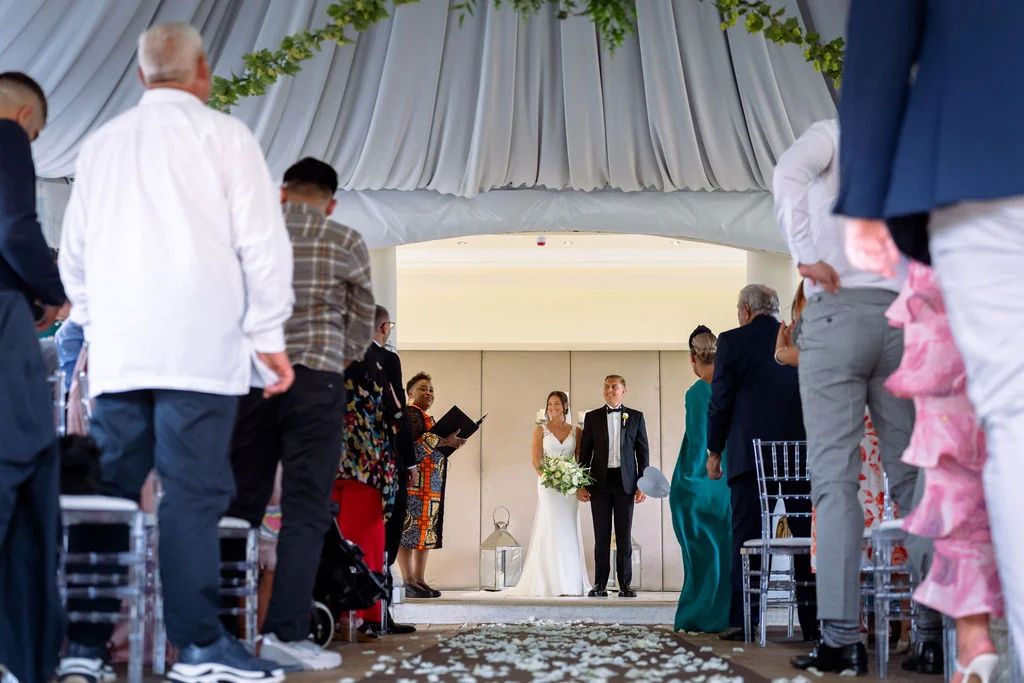 A bride and groom walking down the aisle at a wedding ceremony.