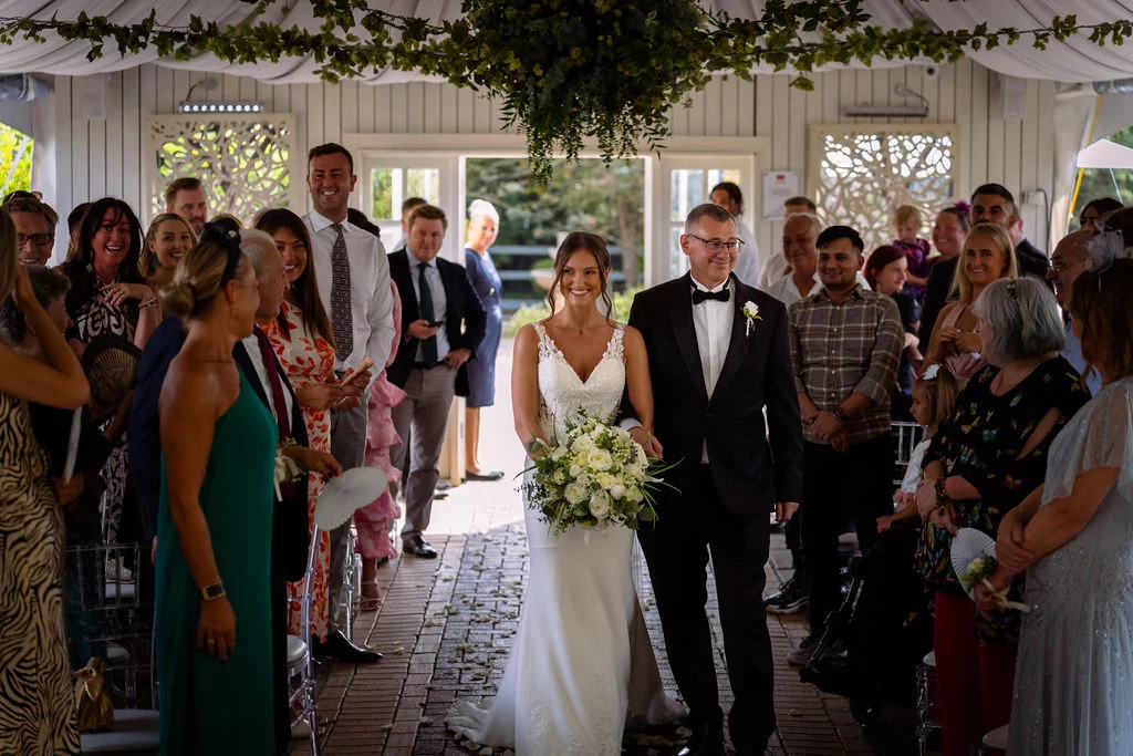 A bride and groom walking down the aisle at a wedding.