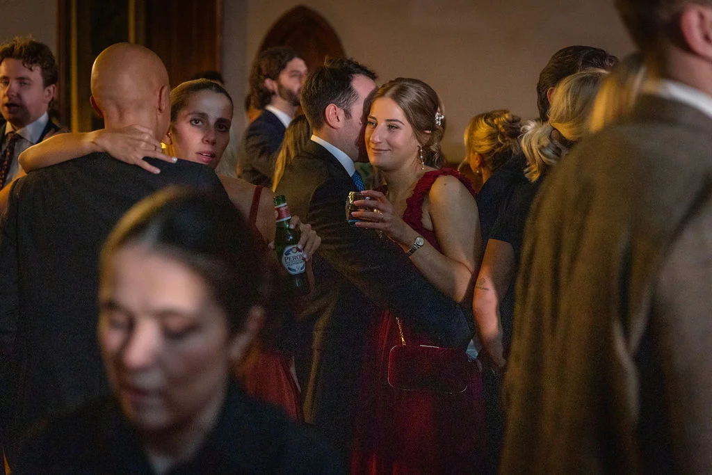 Guests enjoying a lively evening reception, mingling and dancing together in a dimly lit indoor venue.